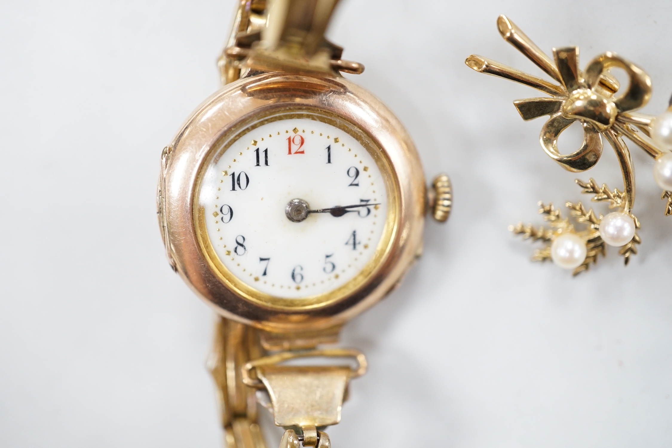 A lady's early 20th century 9ct gold, manual wind wrist watch, on a gold plated strap, together with a modern 9ct gold and seed pearl floral spray brooch.